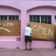 Two men place plywood over a window in Miami Beach. Image: Getty